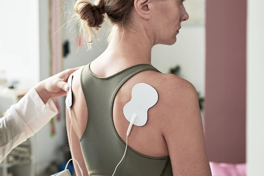 Physiotherapie mit Elektroden auf den Schultern