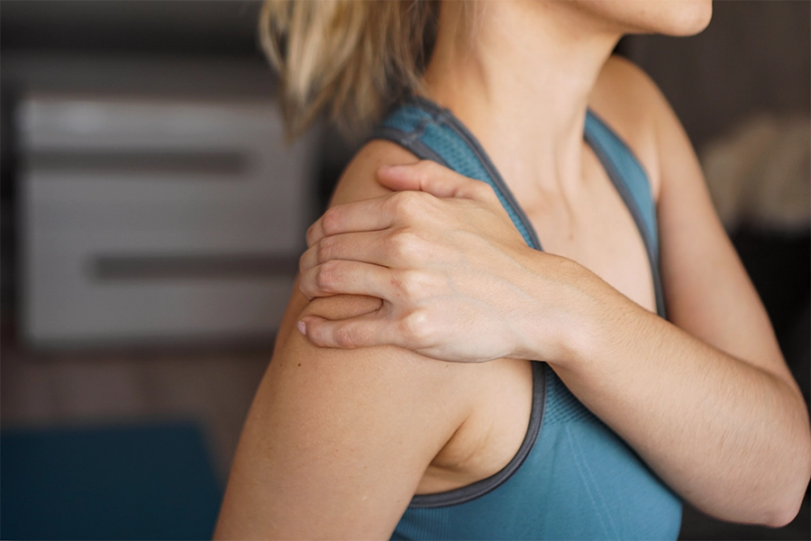 Nahaufnahme einer Fitnessfrau mit Schulterschmerzen nach dem Home-Workout