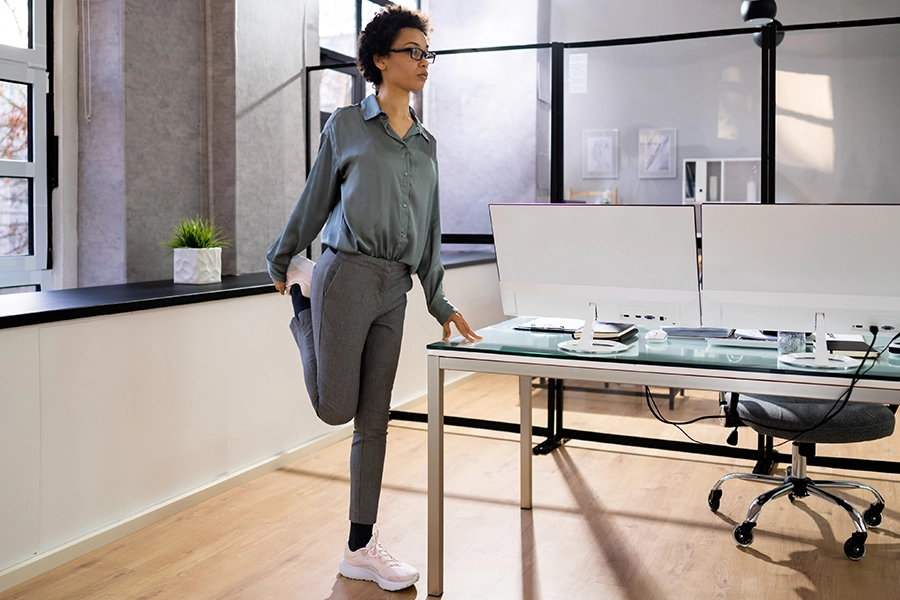 Frau dehnt sich im Büro.