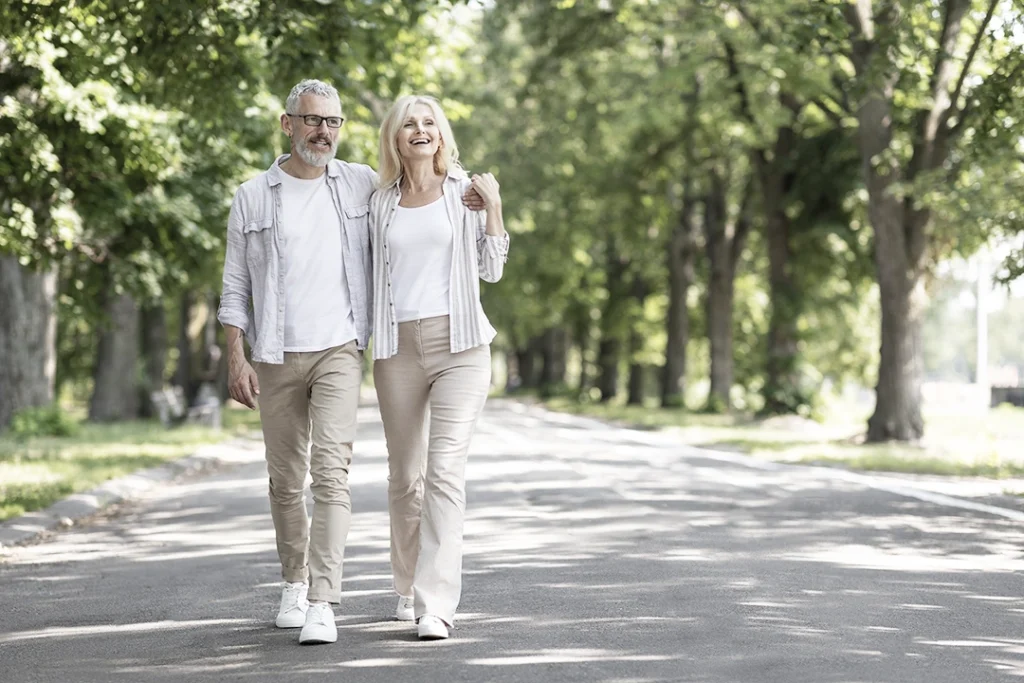 Liebendes reifes Paar umarmt sich beim gemeinsamen Spaziergang im Park