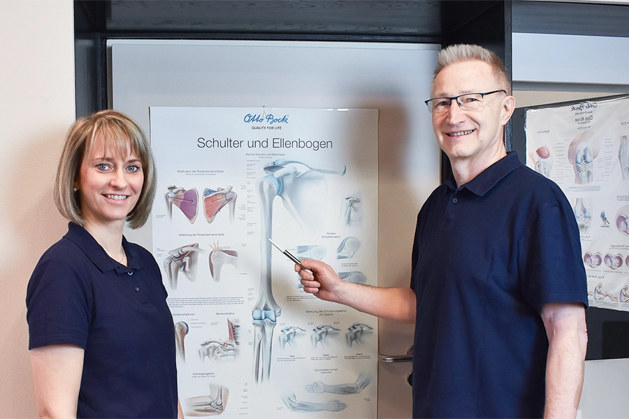 Dr. Pape und Assistentin zeigen anatomische Diagramme.